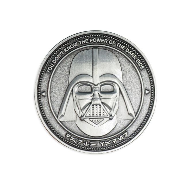 A silver custom coin featuing the menacing face of Darth Vader with the well-known phrase 