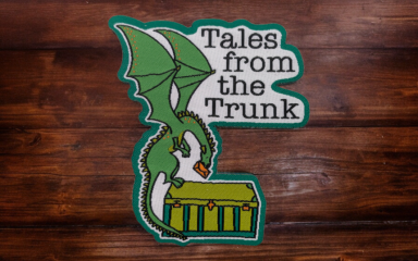 A dragon woven patch with the words Tales from the Trunk written on it.