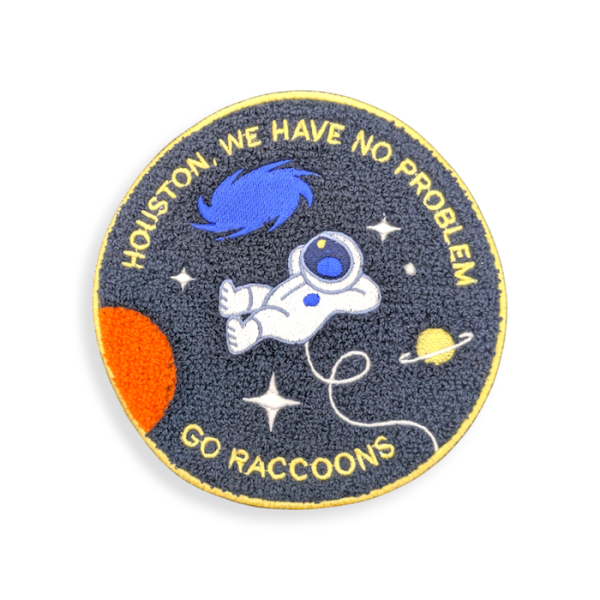 A circular chenille patch with a cartoon astronaut floating in space. The text around the edges reads