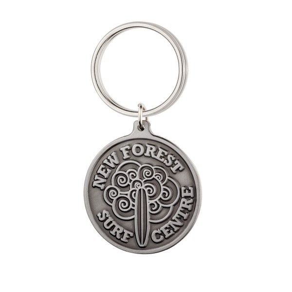 A circular die-struck keyring with a water and surfboard pattern and the words New Forest Surf Central around the edges.