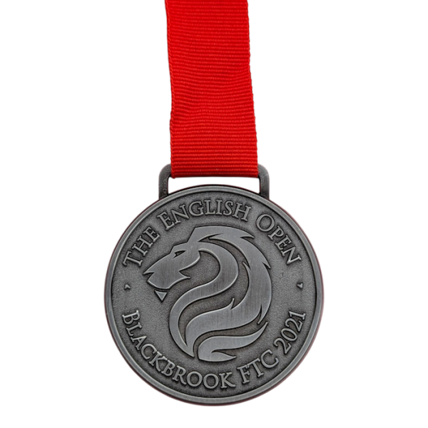 A nickel-plated custom medal for the British Open attached to a red ribbon.