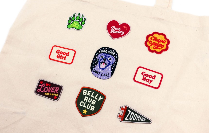 A tote bag with nine dog-related iron-on patches stuck down.
