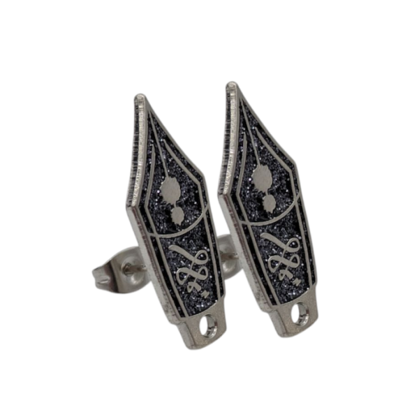 A pair of custom enamel stud earrings designed to look like the nibs of fountain pens with glitter enamel.