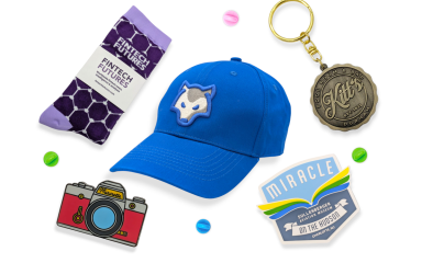 A custom cap, branded socks, keyring, PVC fridge magnet, and pin badge showcasing what you can do for your tradeshow efforts.