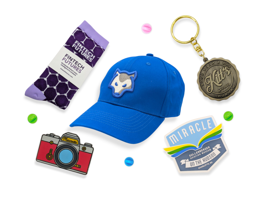 A custom cap, branded socks, keyring, PVC fridge magnet, and pin badge showcasing what you can do for your tradeshow efforts.