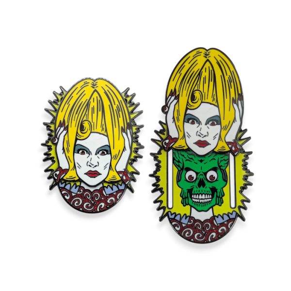 A pin badge showing one of the human characters from Mars Attacks, when you slide her head up it reveals one of the repulsive aliens.