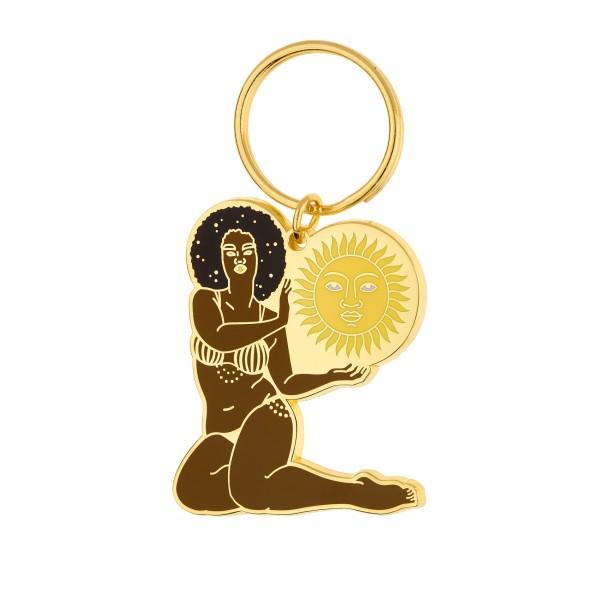 A keyring of a woman with black hair in a yellow bikini is holding a sun while she sits with her legs to one side.