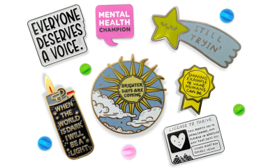 A collection of enamel pins with designs that promote mental health positivity.