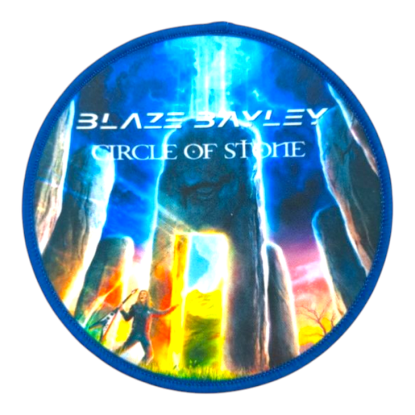 A blue overlocked printed patch with a photo-realistic image of a long haired dude, in Stone Henge holding a guitar. There is electric blue light beaming down from the sky. The words