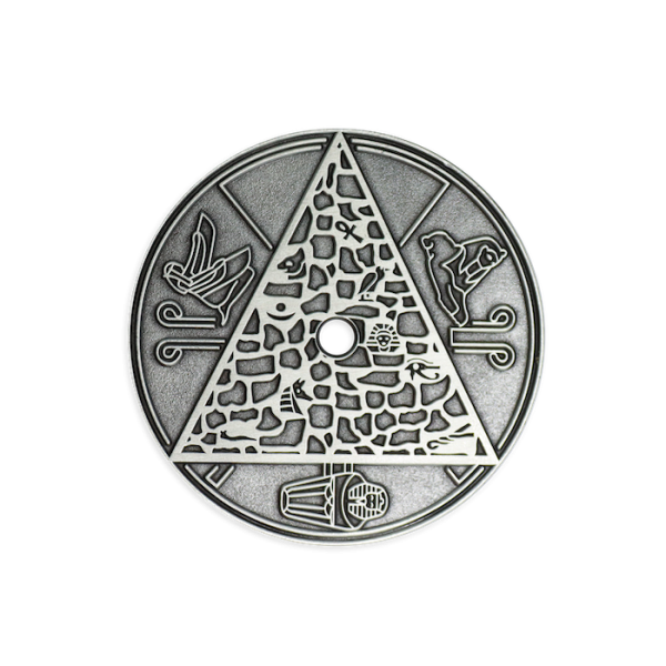 An antiqued silver-plated coin featuring Eygptian icons and drawings.