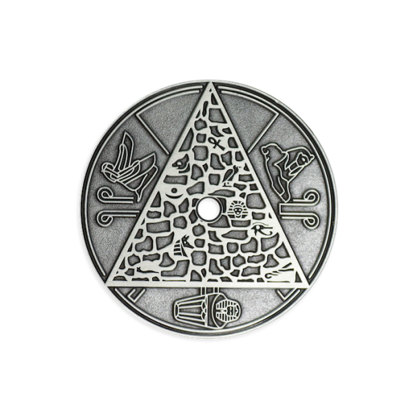 An antiqued silver-plated coin featuring Eygptian icons and drawings.