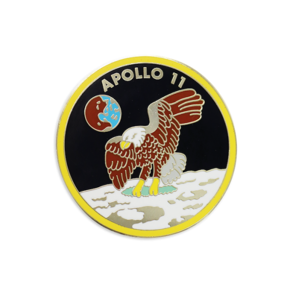 A large hard enamel nasa challenge coin that features an eagle flying over the moon and the words Apollo 11 at the top with the Earth floating in the background.