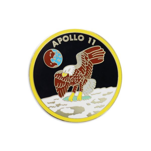 A large hard enamel nasa challenge coin that features an eagle flying over the moon and the words Apollo 11 at the top with the Earth floating in the background.
