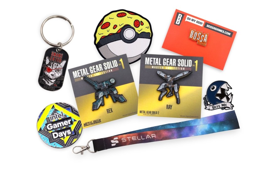 Video game pins and gaming merch including enamel pins, keyrings, lanyards and socks displayed together from some of the biggest names in the industry like Konami, Intel, Pokemon, Nintendo, and Bossa Games.