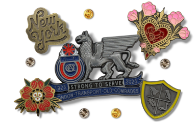 A collection of vintage-looking pin badges in various platings and antique finishes.