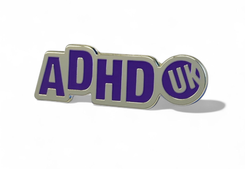 an ADHD UK awareness pin pin badge with silver plating and purple enamel.