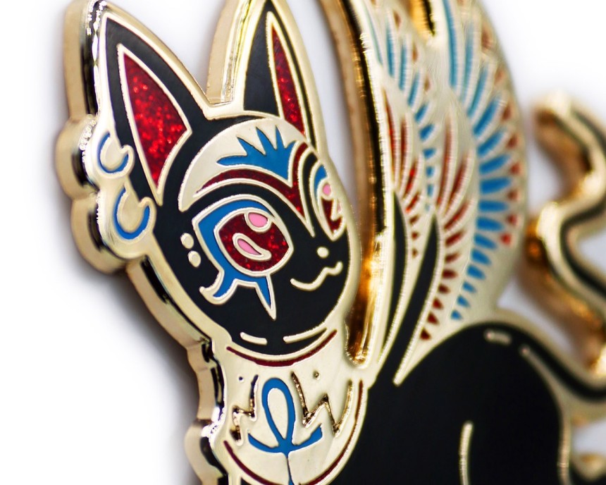 A close up of a beautiful cat pin badge with an Egyptian vibe.