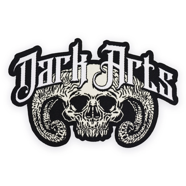 Large woven patch showing a detailed skull with curled horns and gothic “Dark Arts” lettering, created as a high detail custom woven patch for bands, alternative clothing or statement woven patches.